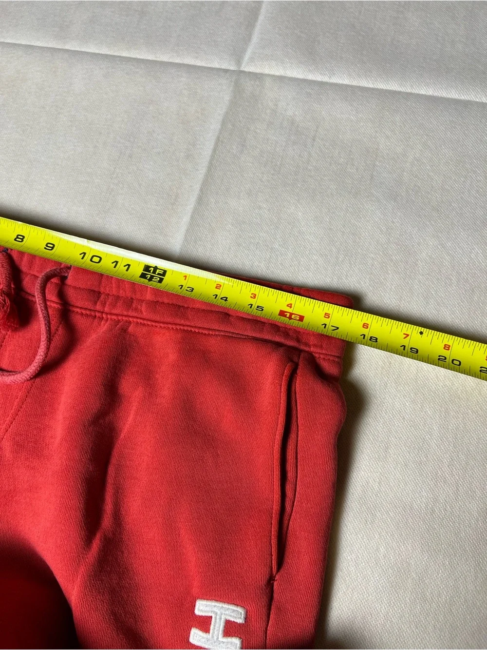 Hollister Co. red sweatpants with white vertical text reading 'HOLLISTER'